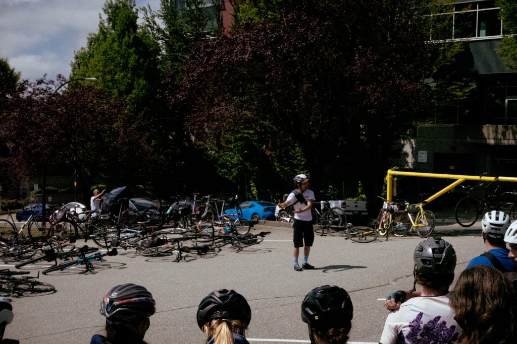 An event organizer discusses the details of a bike race to a crowd