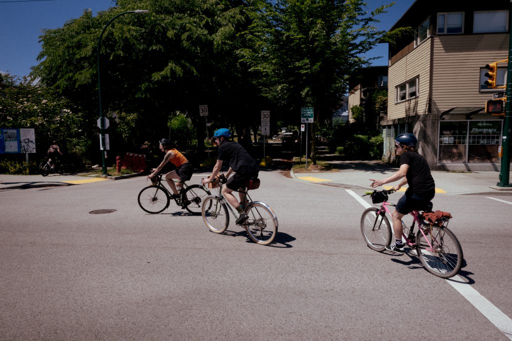 Three cyclists make a left-hand turn while competing in a bike event.