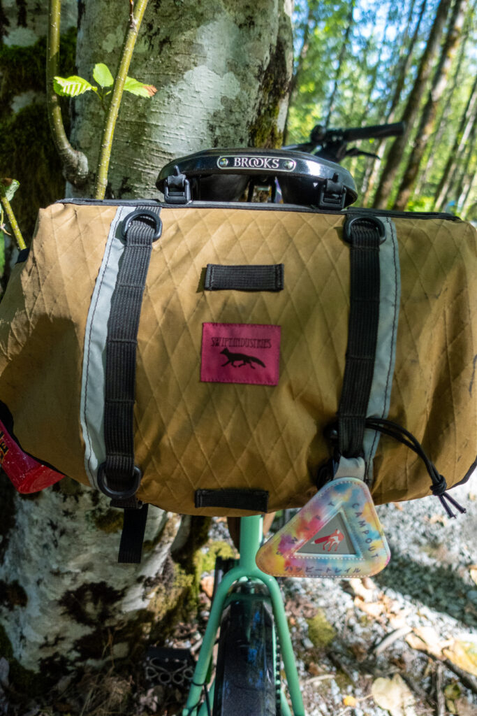 A Swift Industries saddleback is shown with a rainbow reflector hanging off of it.